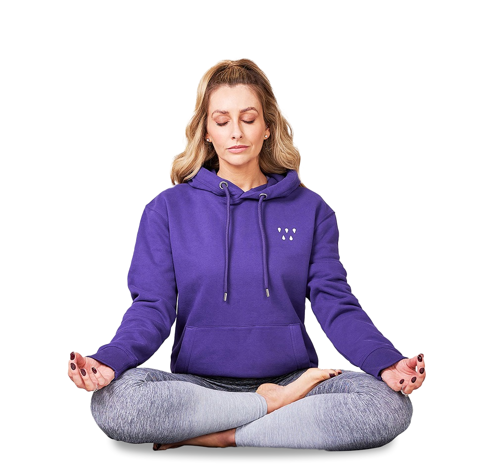 Gemma Merna meditating with crossed legs wearing a purple Mind and Wellness branded hoodie